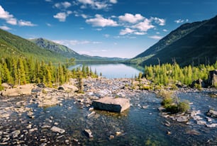 Aerial view of mountain torrent with rapids. The stream flows out of a delightful lake in wilderness