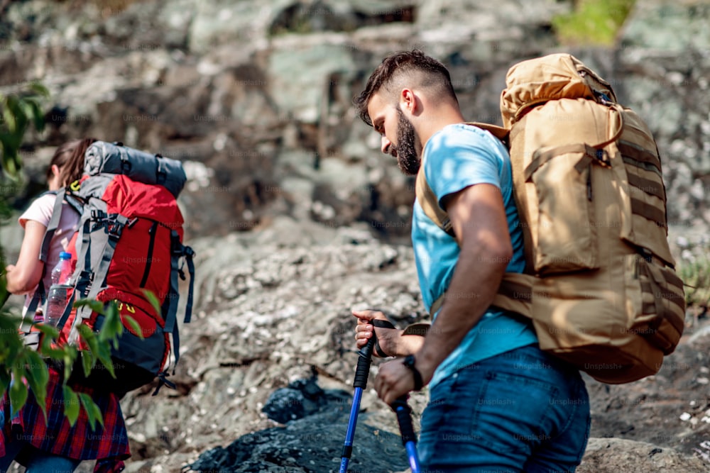 Hikers with backpacks climbing through mountain hills.Hiking, tourism and lifestyle concept.