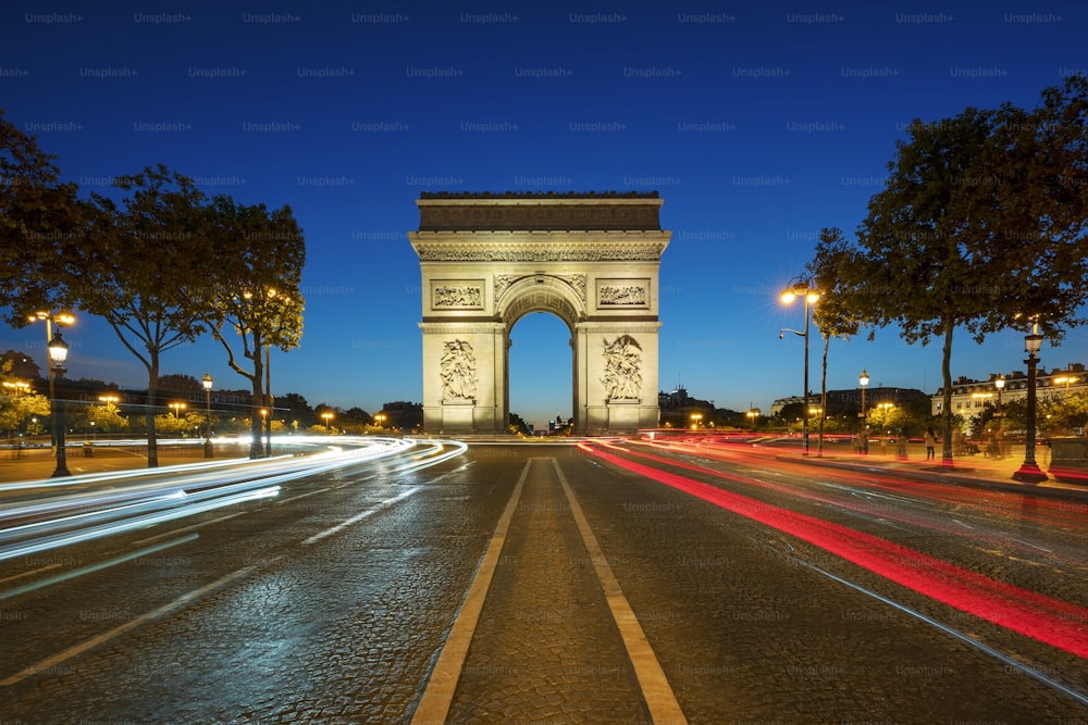 Famoso Arco do Triunfo à noite, Paris, França.