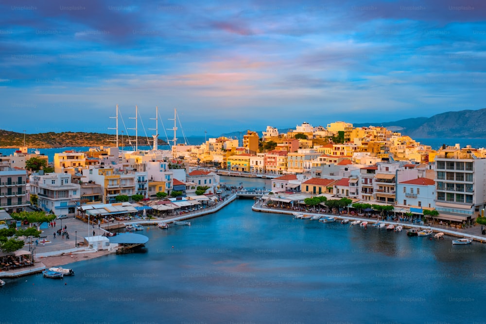 Schöne Agios Nikolaos Stadt am See Voulismeni bei Sonnenuntergang. Lasithi Region der Insel Kreta, Griechenland