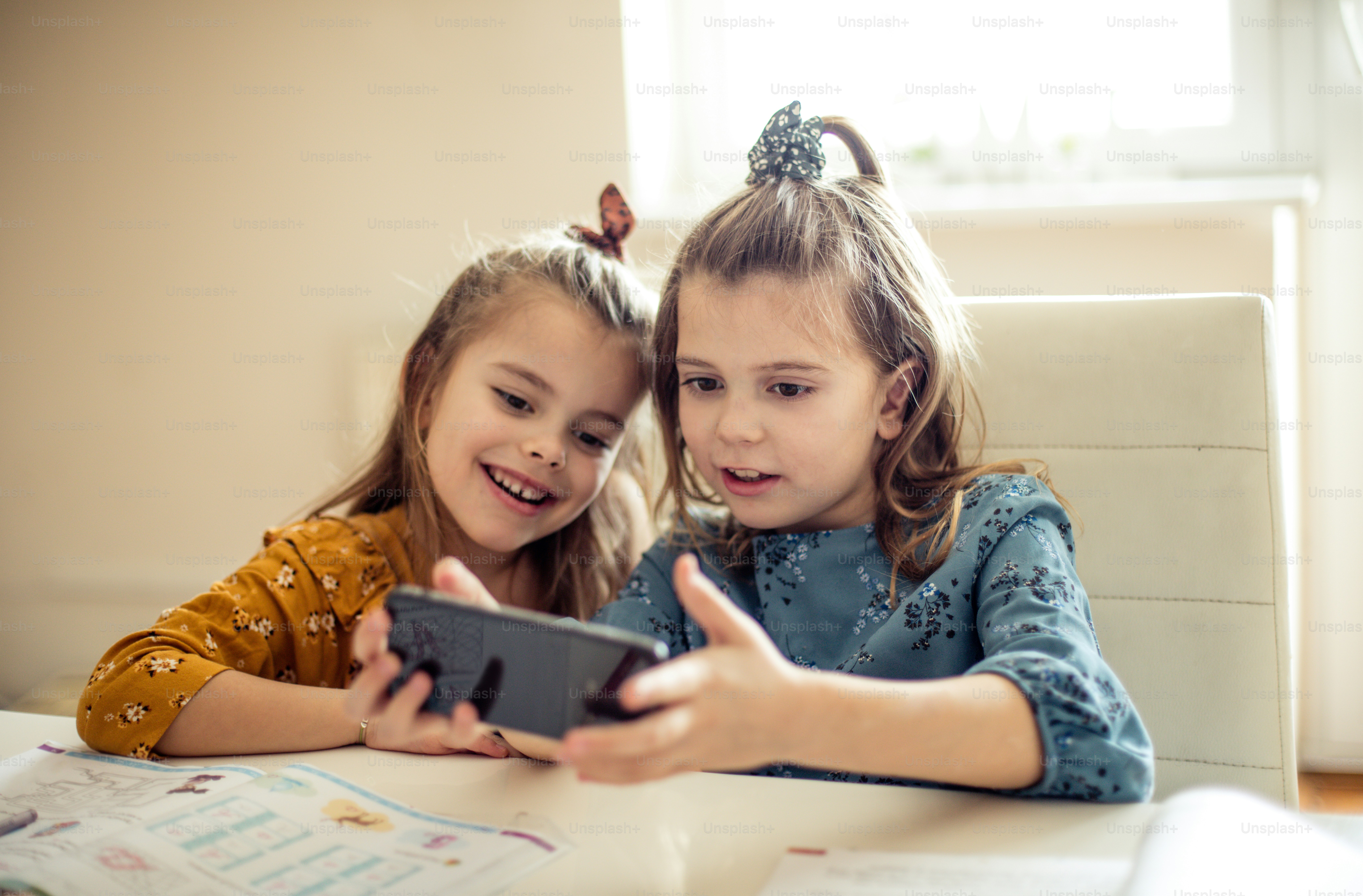 Comment cela fonctionne-t-il ? Deux petites écolières utilisant le téléphone.