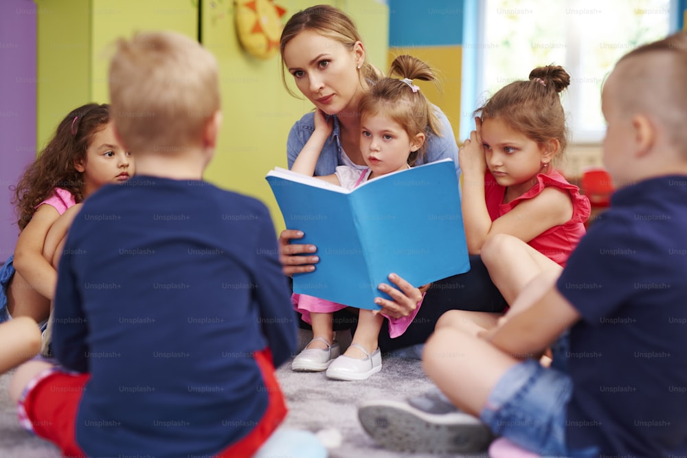Female teacher is reading a book during classes in preschool