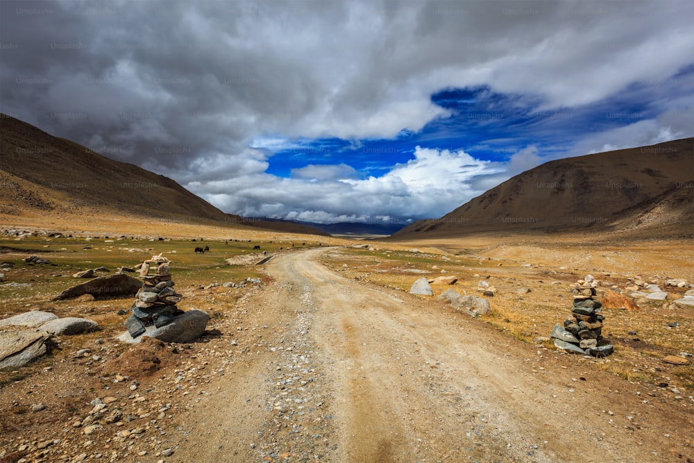 Road in Himalayas with stone cairns. Ladakh, Jammu and Kashmir, India