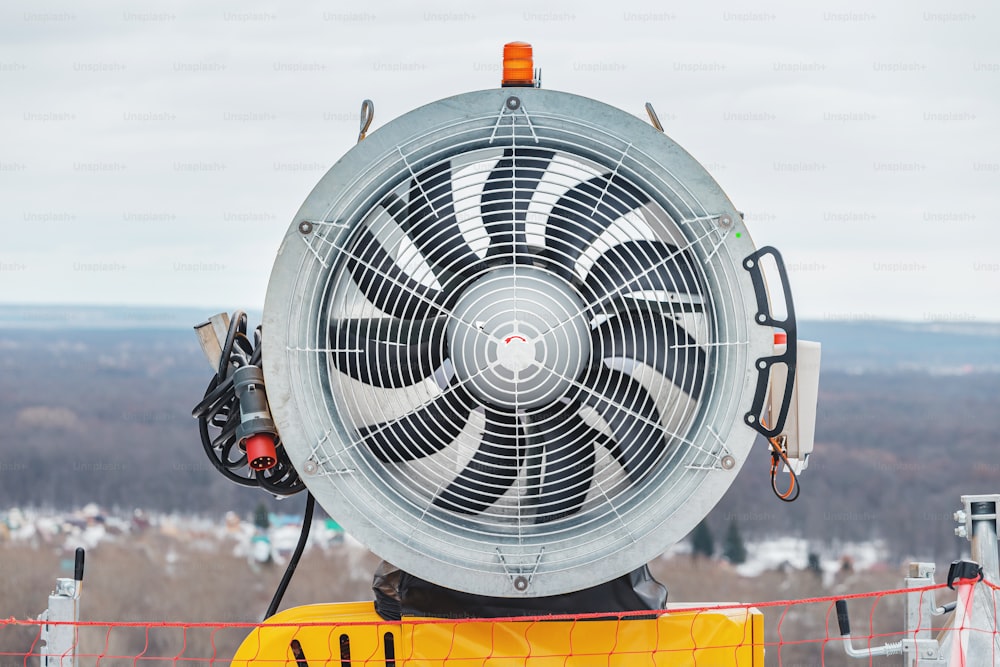 Disabled snow cannon fan on a ski slope at spring