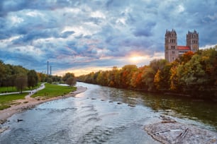 Vista de Múnich: el río Isar, el parque y la iglesia de San Maximiliano desde el puente de Reichenbach al atardecer. München, Baviera, Alemania.