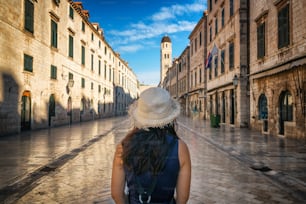 Promenades de voyageur sur la rue historique de Stradun (Placa) dans la vieille ville de Dubrovnik en Croatie - Destination de voyage de premier plan de Croatie. La vieille ville de Dubrovnik a été classée au patrimoine mondial de l’UNESCO en 1979.