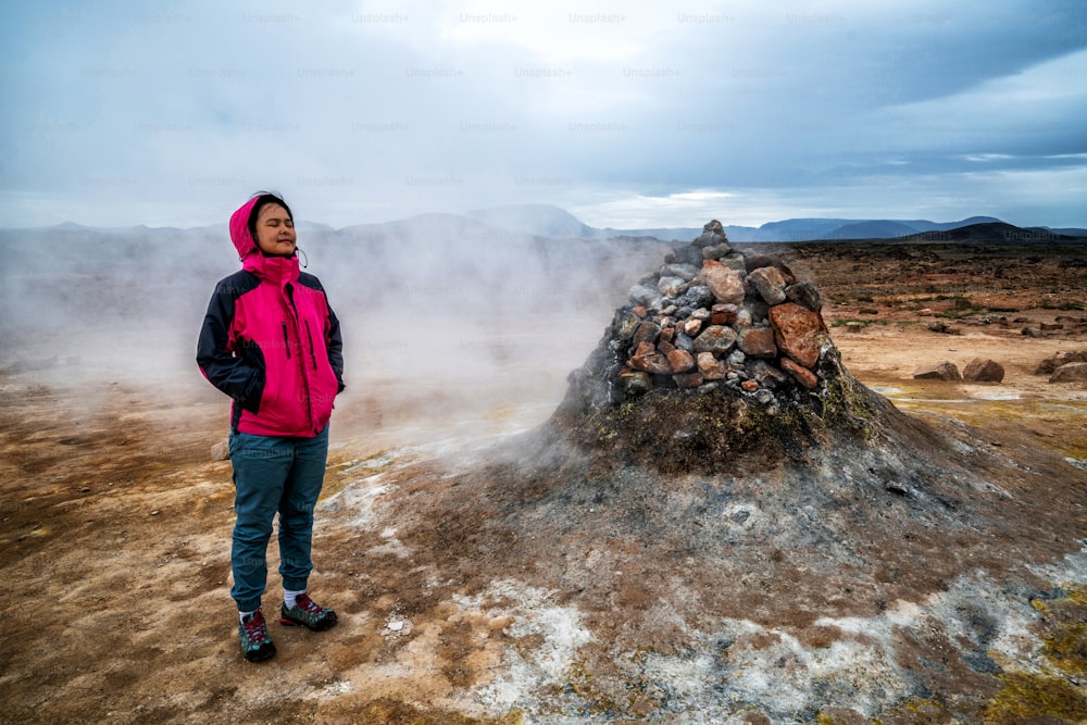 女性旅行者がアイスランドのフヴェリルを旅行します。クヴェリル(アイスランド語: Hverarond)は、マイヴァトンにある地熱地帯である。ヨーロッパのアイスランド北東部のクラフラにあるミーヴァトン湖の近くにある有名な目的地です。
