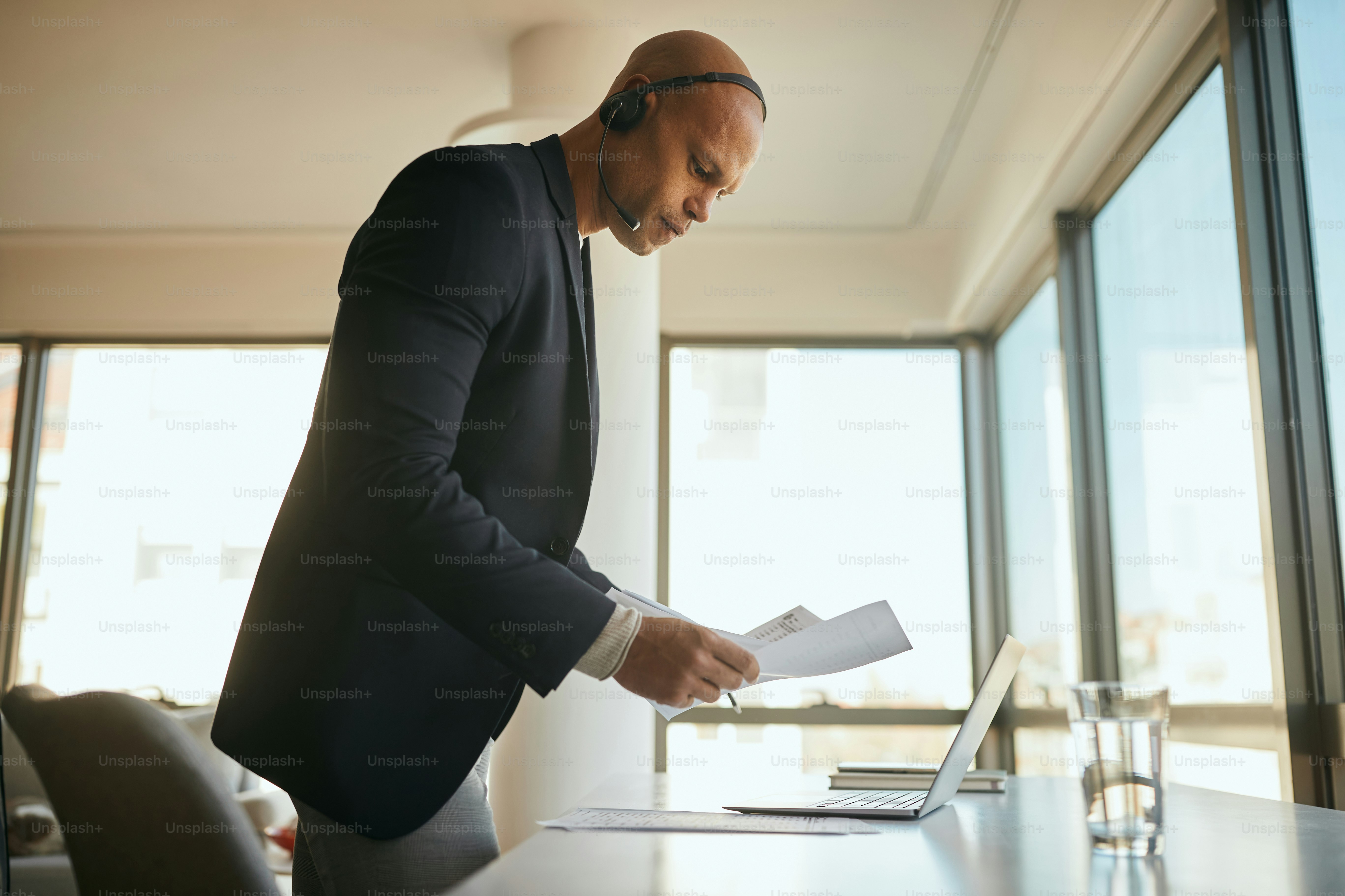 Young African American businessman going through paperwork while working in the office.