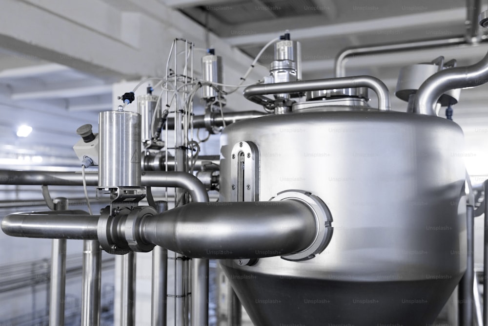 Industrial background. Equipment, industrial tools and machinery for the production in factory shops. Brewery manufacturing factory. Stainless steel vats or tanks with pipes, small equipment, modern production technology, toned