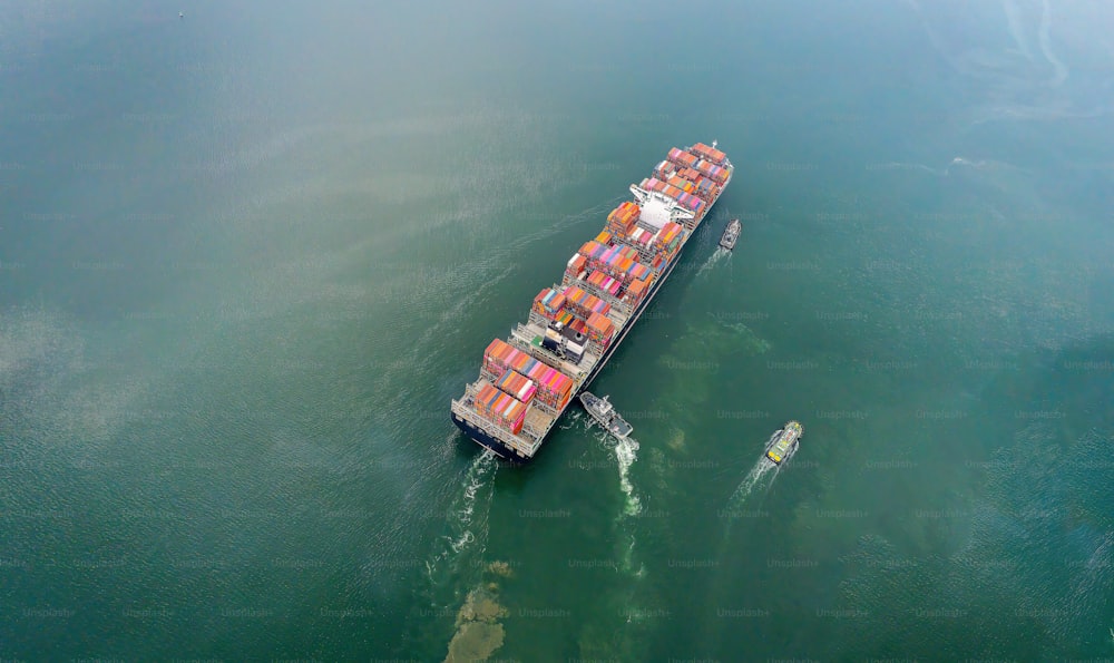 Aerial top view containers ship cargo business commercial trade logistic and transportation of international import export by container freight cargo ship in the open seaport.