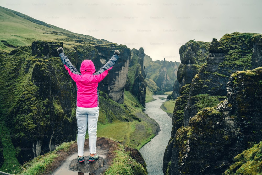 Woman traveller hike Fjadrargljufur in Iceland. Top tourism destination. Fjadrargljufur Canyon is a massive canyon about 100 meters deep and about 2 kilometers long, located in South East of Iceland.