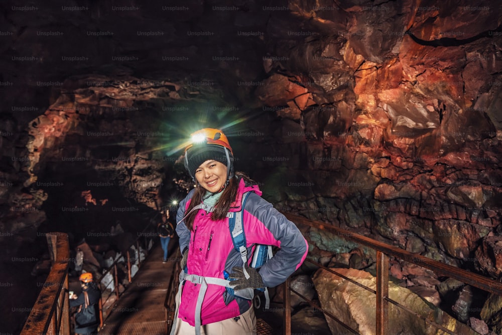 Weibliche Reisende erkunden Lavatunnel in Island. Raufarholshellir ist eine wunderschöne versteckte Welt der Höhle. Es ist eine der längsten und bekanntesten Lavaröhren in Island, Europa für unglaubliche Abenteuer.