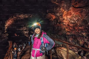 アイスランドの溶岩トンネルを探検する女性旅行者。ラウファルホルシェリルは、洞窟の美しい隠された世界です。ヨーロッパのアイスランドで最も長く、最も有名な溶岩洞の1つで、信じられないほどの冒険を楽しめます。