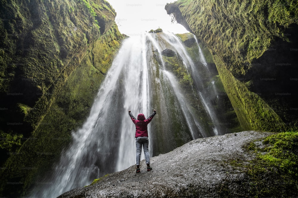 Traveler stunned by Gljufrabui waterfall cascade in Iceland. Located at scenic Seljalandsfoss waterfall South of Iceland, Europe. It is top beautiful destination of popular tourist travel attraction.