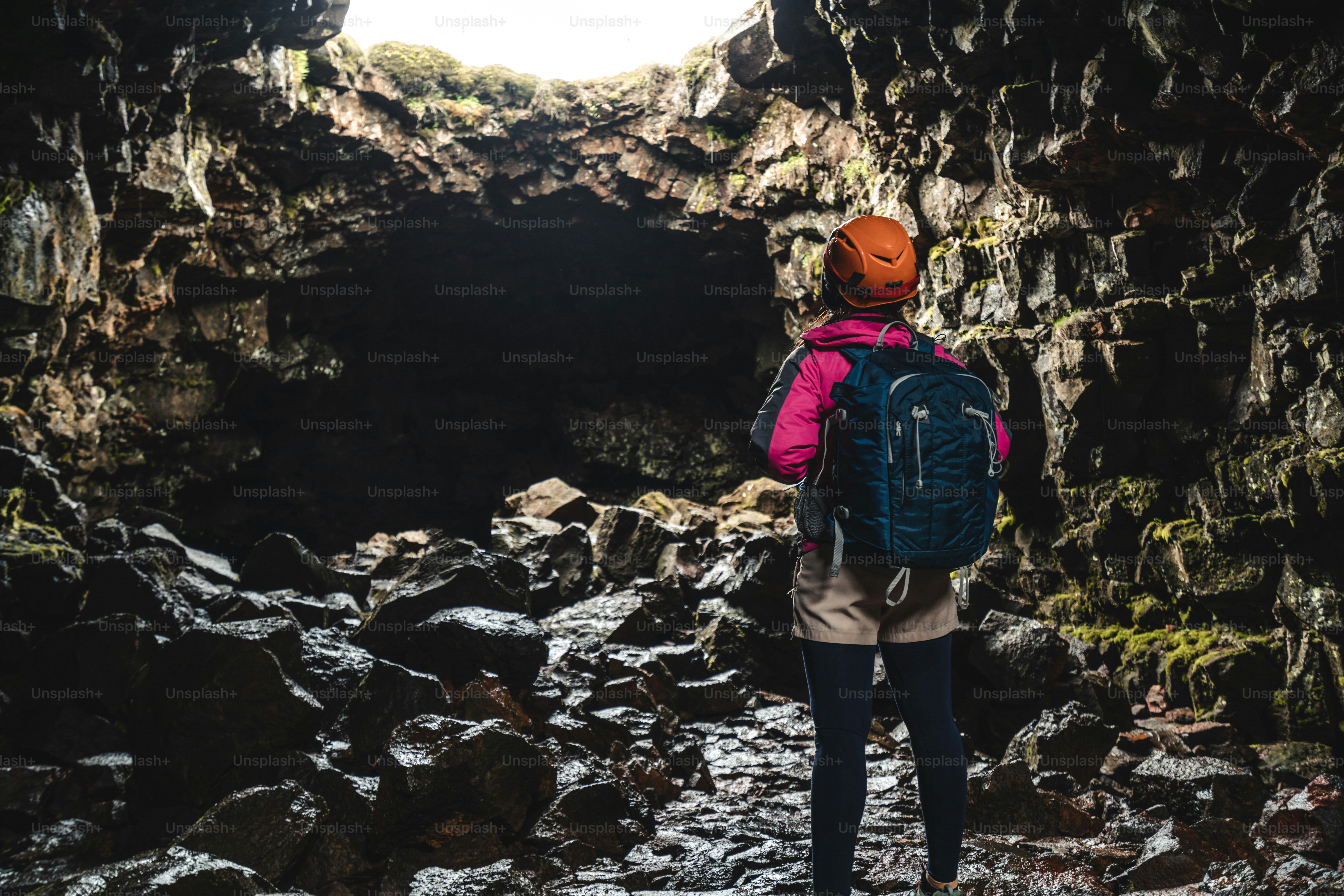 Woman traveler explore lava tunnel in Iceland. Raufarholshellir is a beautiful hidden world of cave. It is one of the longest and best-known lava tubes in Iceland, Europe for incredible adventure.