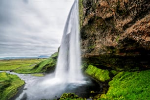 Cachoeira mágica de Seljalandsfoss na Islândia. Está localizado perto do anel viário do sul da Islândia. Majestoso e pitoresco, é um dos lugares de tirar o fôlego mais fotografados da Islândia.