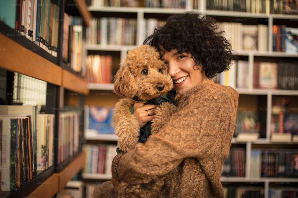 Mulher feliz com seu cão na biblioteca.