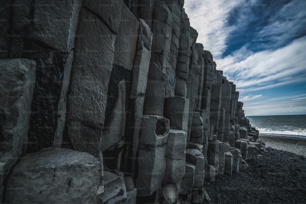 Wunderschöne und einzigartige vulkanische Felsformation am isländischen schwarzen Sandstrand in der Nähe des Dorfes Vik i Myrdalin Südisland. Sechseckige säulenförmige Felsen ziehen Touristen an, die Island besuchen.