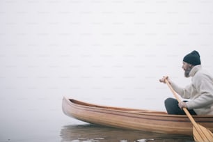 Side view of man paddling canoe in the winter, copy space.