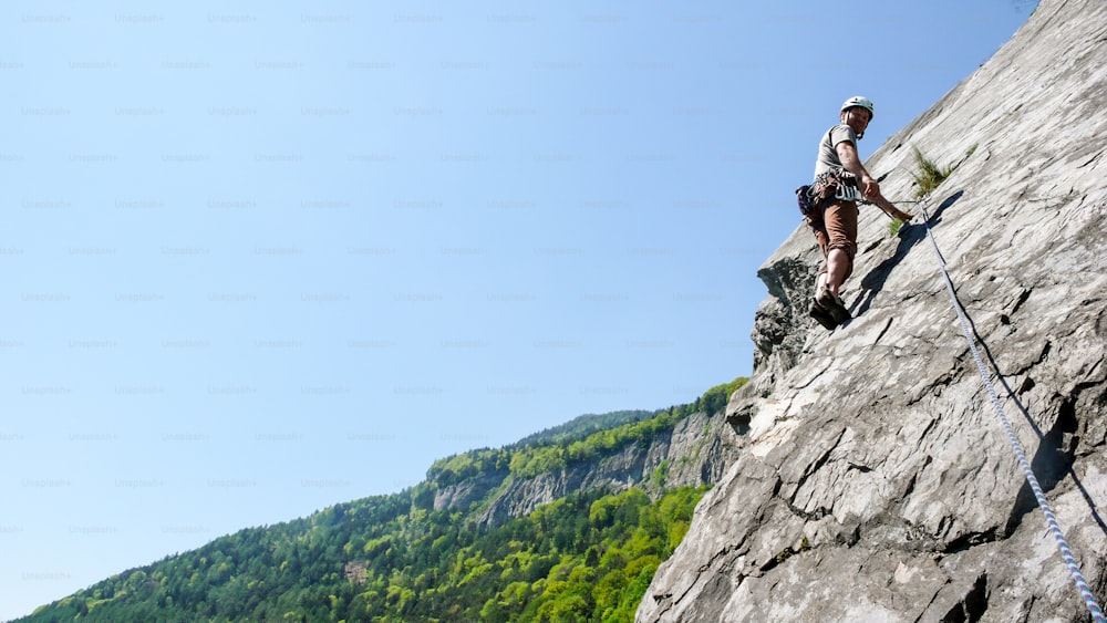 山岳ガイドのロッククライマーは、ハルデンシュタイン近くの美しい日にスイスのアルプスのスラブ石灰岩登山ルートで