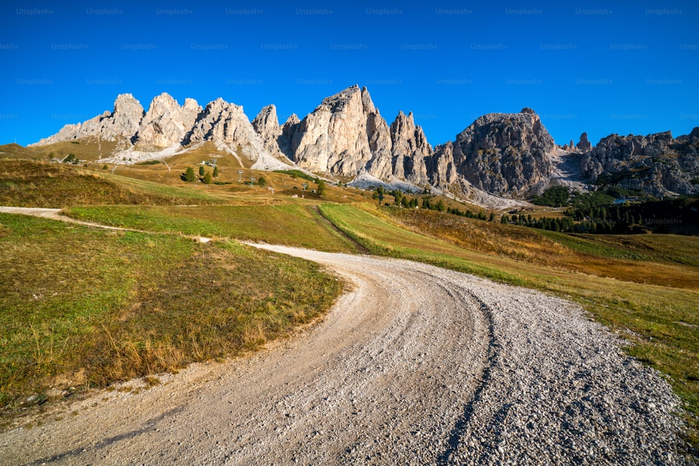 Strada sterrata e sentiero escursionistico in montagna delle Dolomiti, Italia, di fronte alle catene montuose della cresta Pizes de Cir a Bolzano, Alto Adige, Dolomiti nord-occidentali, Italia.
