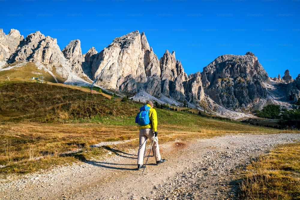 イタリアの夏の日の出に、息をのむようなドロミテ山脈の風景の中を一人でハイキングする男性旅行者。旅行ライフ スタイルの放浪癖の冒険のコンセプトです。屋外の荒野での休暇。
