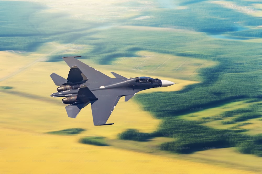 Avion de chasse dans le ciel à grande vitesse effectuant une mission de combat avec en arrière-plan le paysage de champs et de forêts