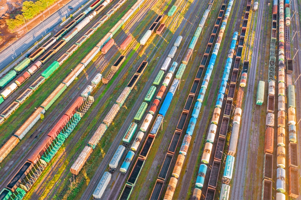 Stazione merci di smistamento ferroviario con vari vagoni ferroviari, con molti binari ferroviari. Vista aerea del paesaggio dell'industria pesante