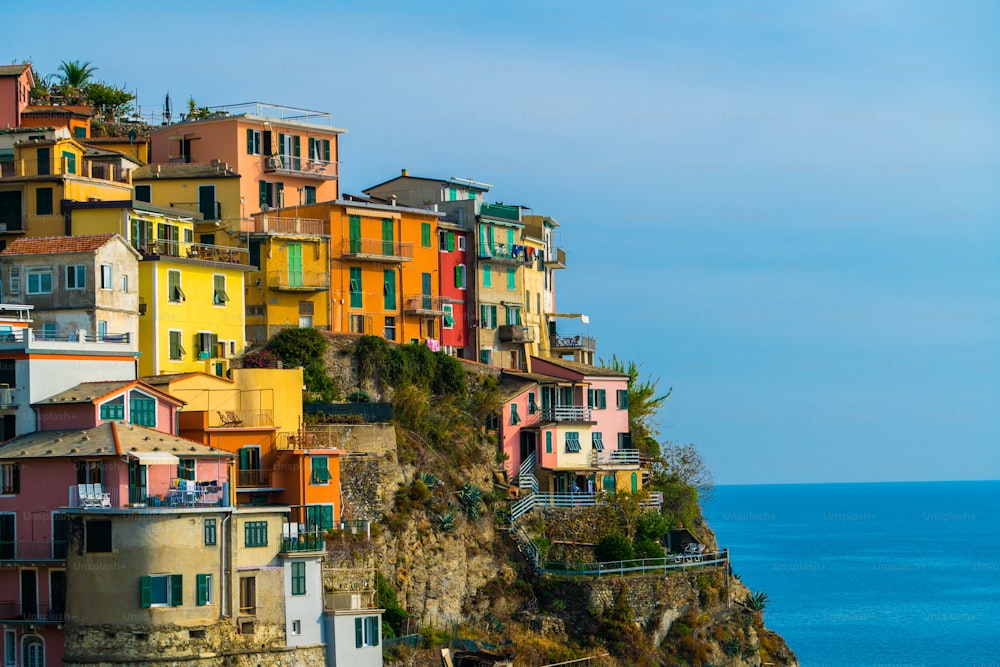 イタリアのチンクエテッレ海岸のマナローラ村にあるカラフルな家々。マナローラは、イタリアの北、リグーリア州ラスペツィア県にある美しい小さな町で、チンクエテッレの5つのアトラクションの1つです。