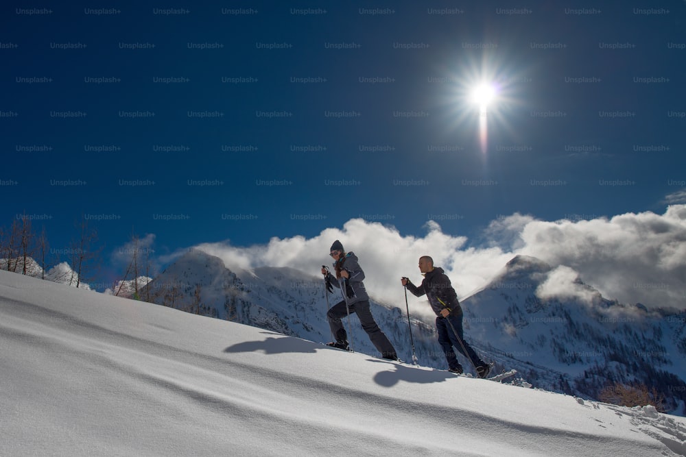 Snowshoes practiced by a boy and a girl in the warm mountain sun.