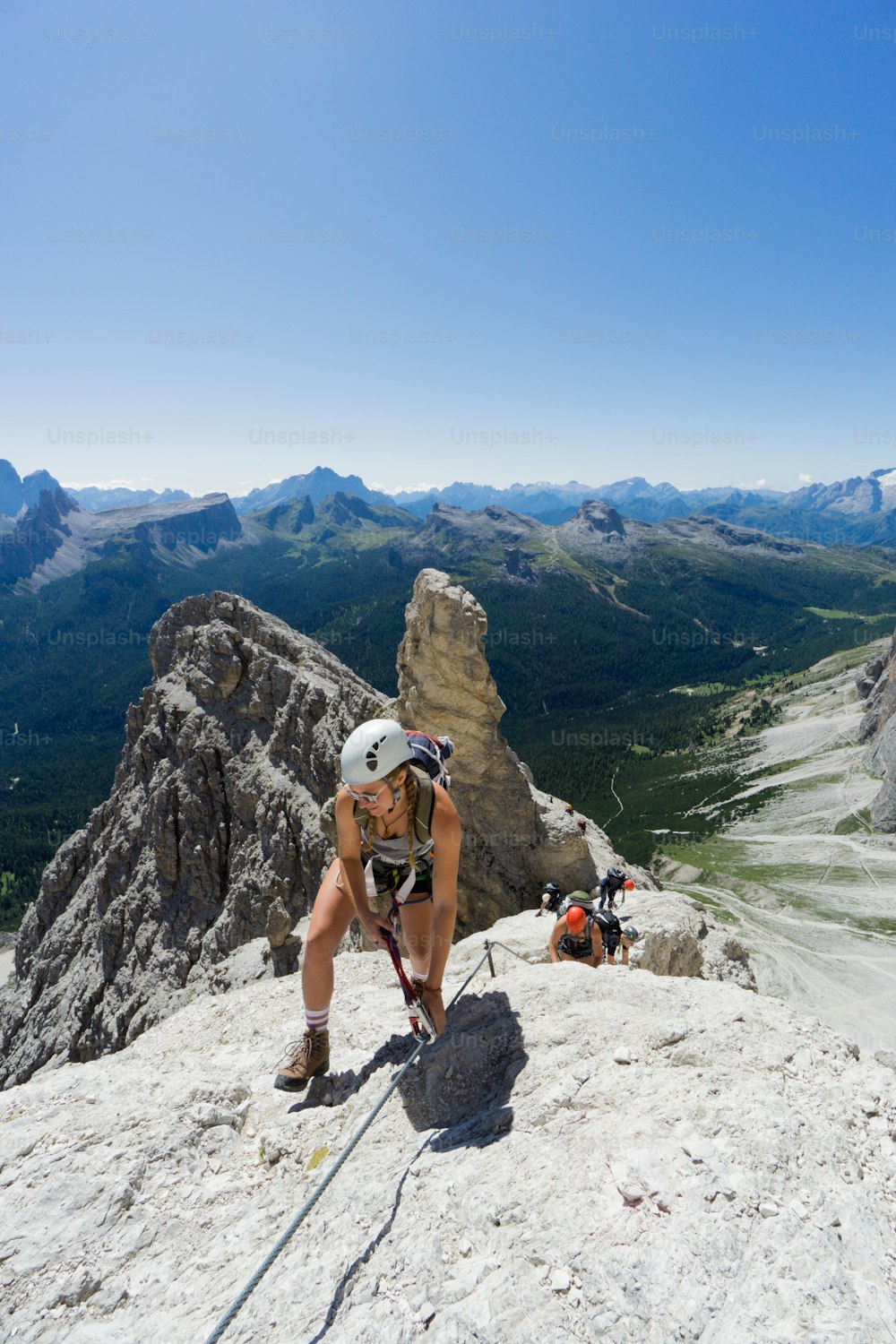 Bergsteigergruppe auf einem steilen Klettersteig mit grandiosem Blick auf die italienischen Dolomiten
