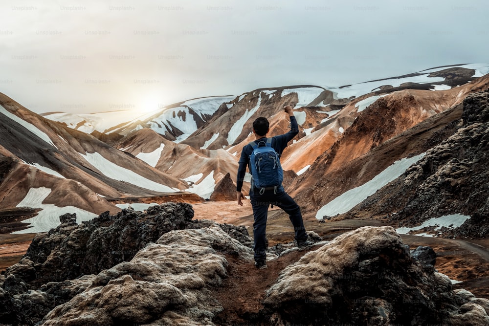 아이슬란드, 북유럽, 유럽의 고원에 있는 란드만날뢰이가르(Landmannalaugar)의 초현실적인 자연 풍경에서 하이킹을 즐기는 여행자. 여름 트레킹 모험과 야외 산책으로 유명한 아름다운 다채로운 눈 산 지형.