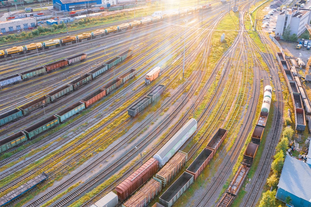 Vuelo de vista aérea sobre la estación de carga de clasificación de ferrocarril con varios vagones, con muchas vías férreas de ferrocarril. Panorama de la industria pesada