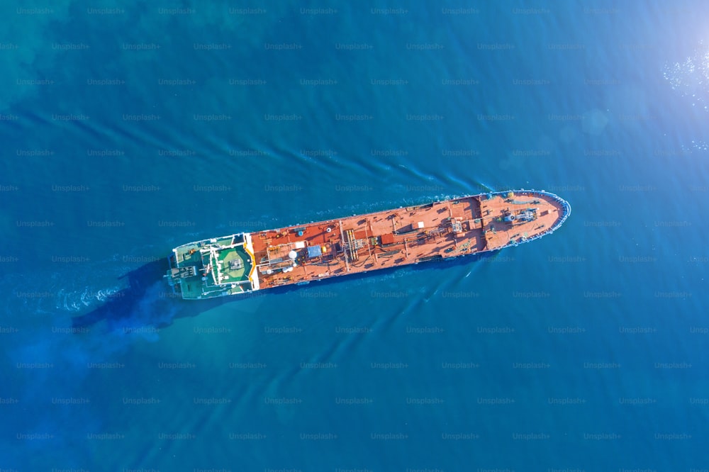 Un navire-citerne à vue aérienne avec une cargaison de vrac liquide navigue dans l’eau bleue