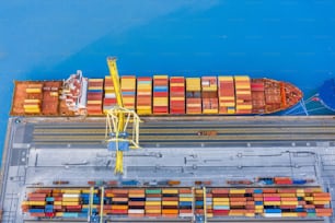 Aerial view from the height of the port dock, moored cargo ship arriving from the ocean in anticipation of unloading containers