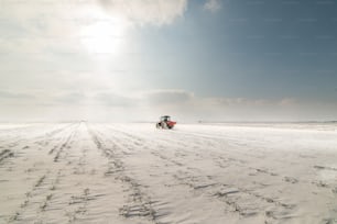 Agricultor con tractor que siembra - siembra de cultivos en campos agrícolas en invierno - nieve
