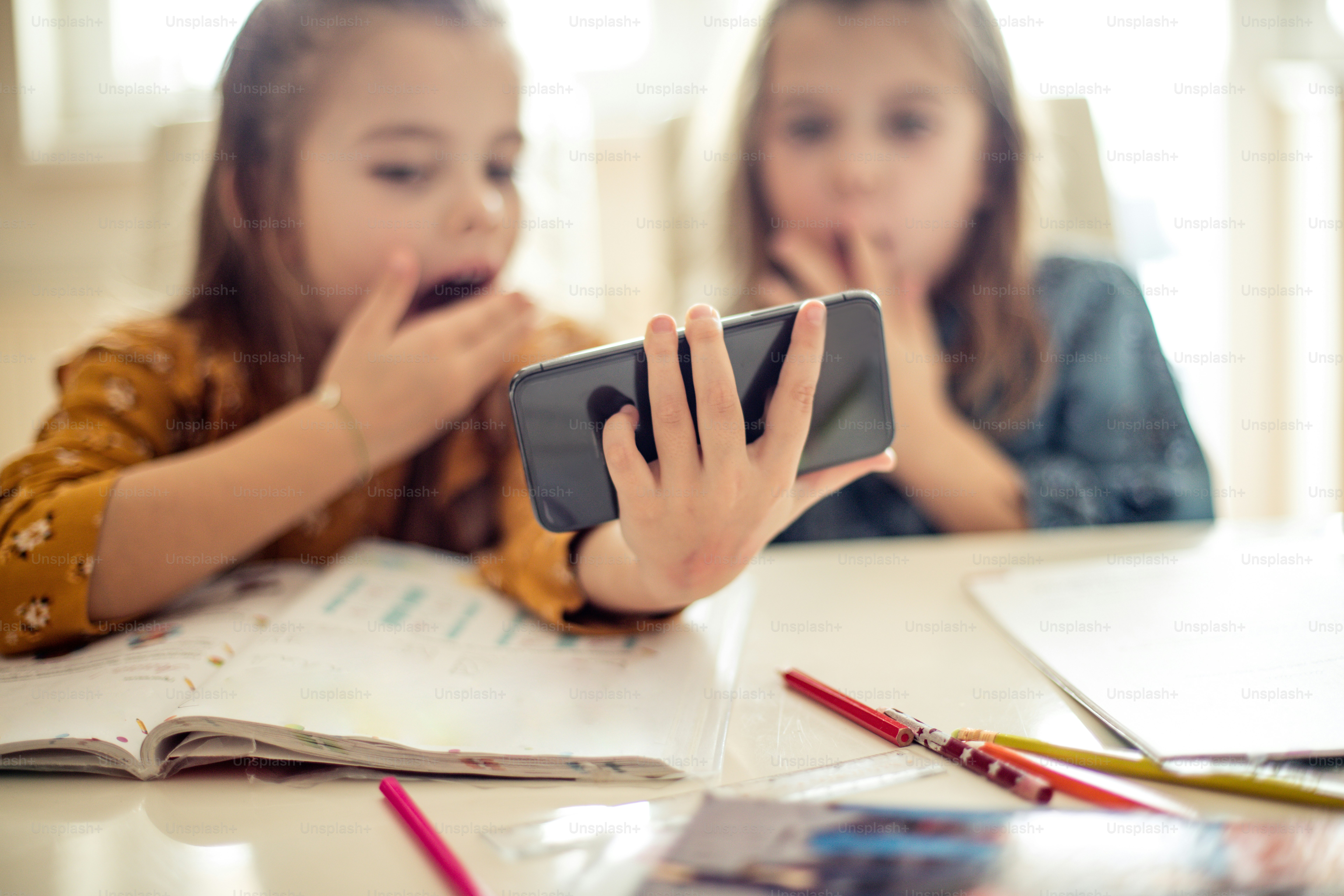 Oh mon dieu. Deux petites écolières utilisant un téléphone intelligent. Espace de copie.