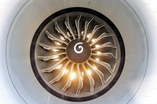 The engine of the airplane is close to the bright light from the sun through the blades
