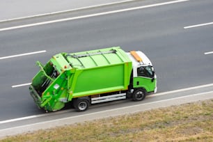 Recycling green eco truck rides on the road in the city
