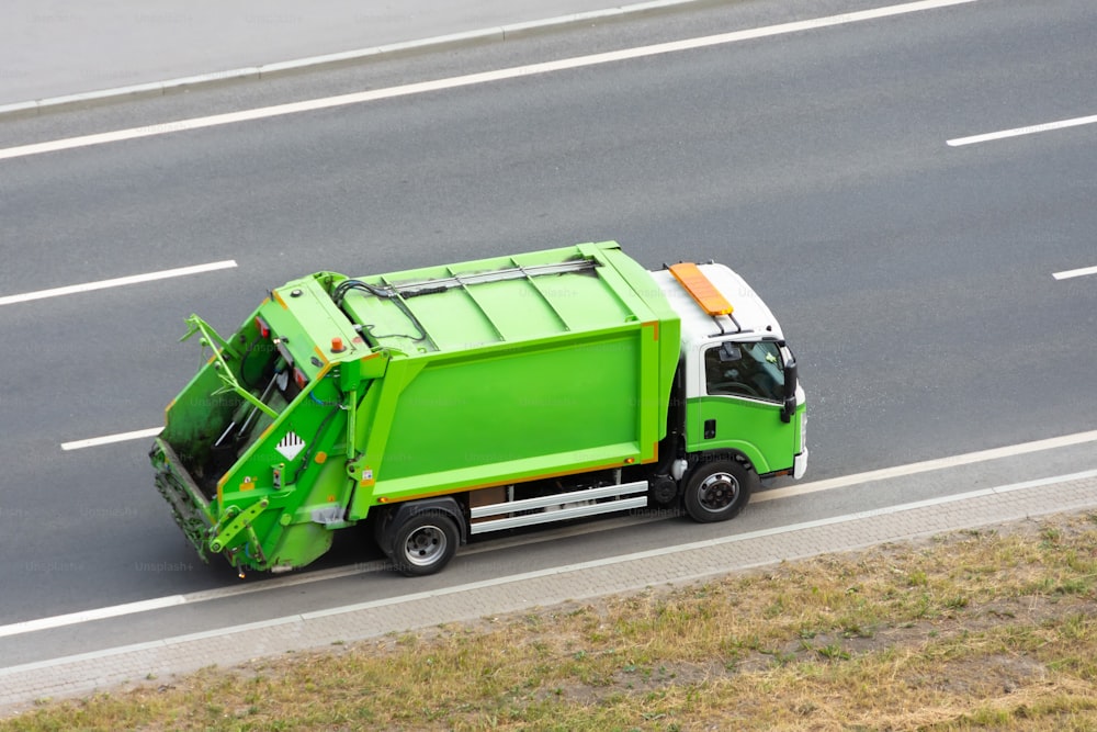Recycling green eco truck rides on the road in the city
