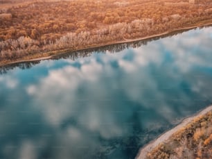 Aerial view of dramatic sunset sky reflecting in river, at autumn time