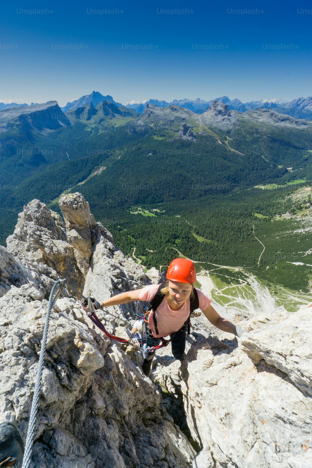 jolie alpiniste brune sur une Via Ferrata raide dans le Tyrol du Sud