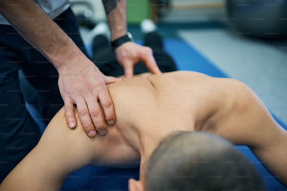 Close-up of athlete having physical therapy treatment of his back at rehabilitation center.