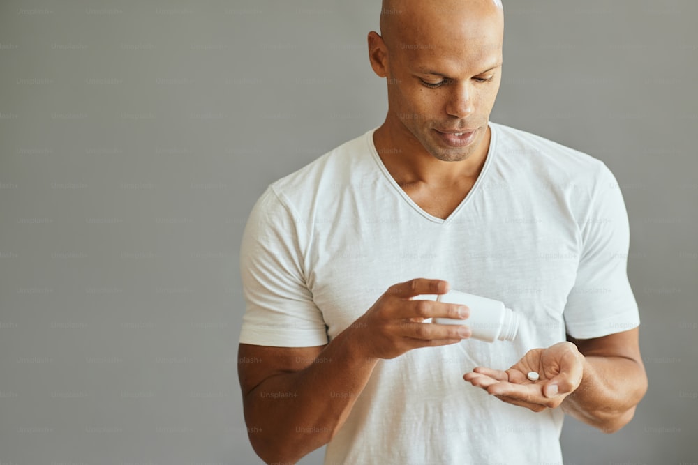 Young African American man taking a pill. Copy space.