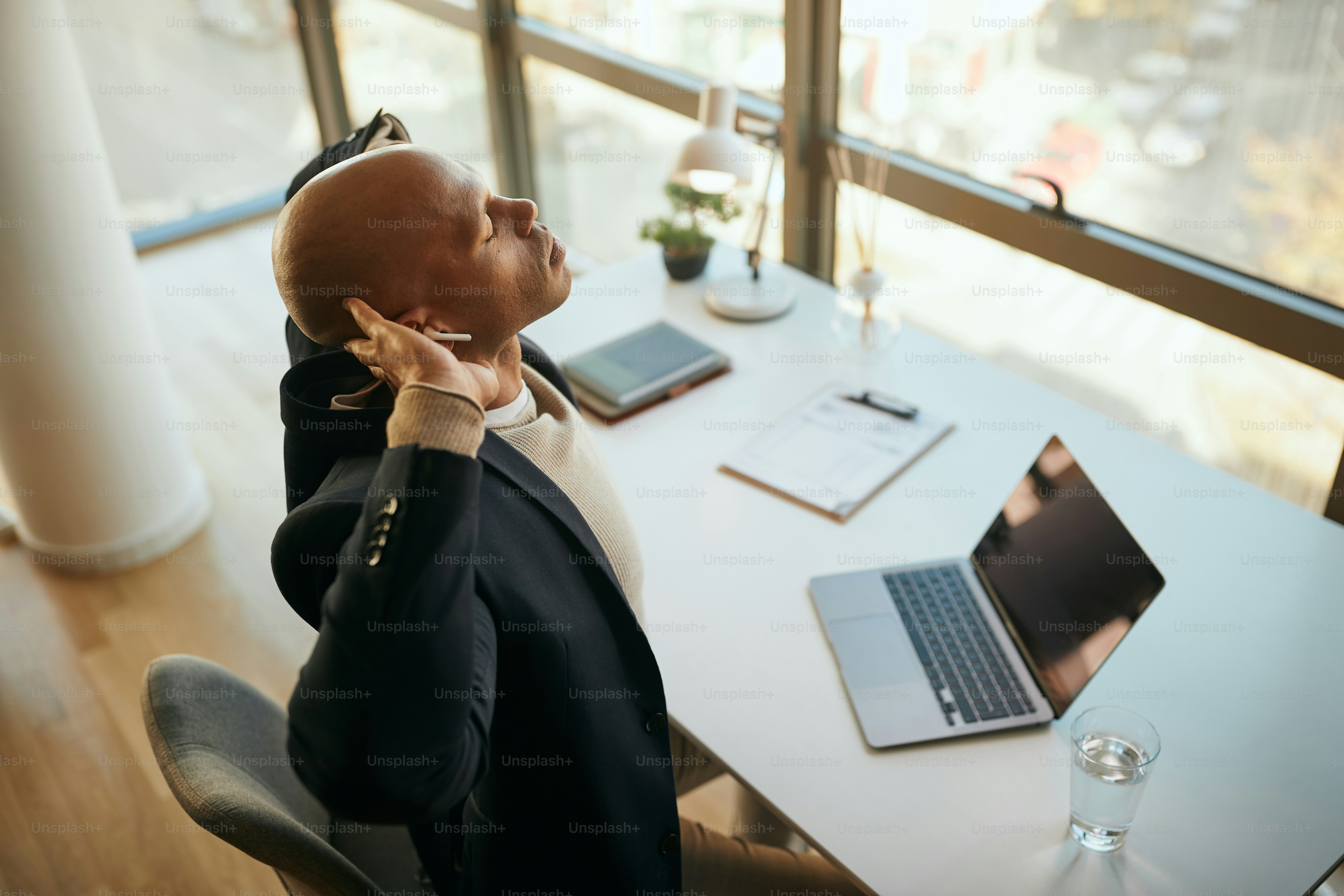 Un homme d'affaires afro-américain se sent épuisé après avoir travaillé sur  un ordinateur portable et s'être étiré au bureau. photo – Image de Bureau  sur Unsplash, image size:3000x2000