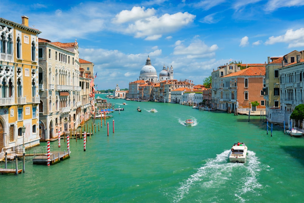 Blick auf den Canal Grande von Venedig mit Booten und die Kirche Santa Maria della Salute am Tag von der Brücke Ponte dell'Accademia. Venedig, Italien