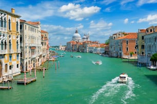 View of Venice Grand Canal with boats and Santa Maria della Salute church in the day from Ponte dell'Accademia bridge. Venice, Italy