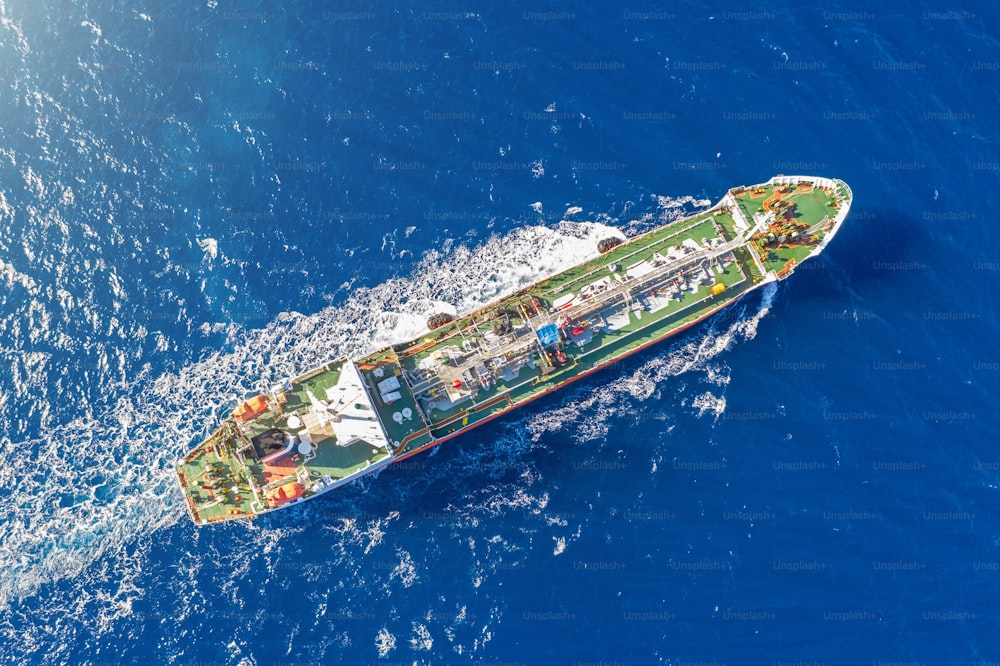 Ship, with bulk cargo, sails in the blue sea. Aerial view