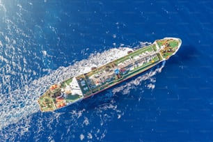 Ship, with bulk cargo, sails in the blue sea. Aerial view