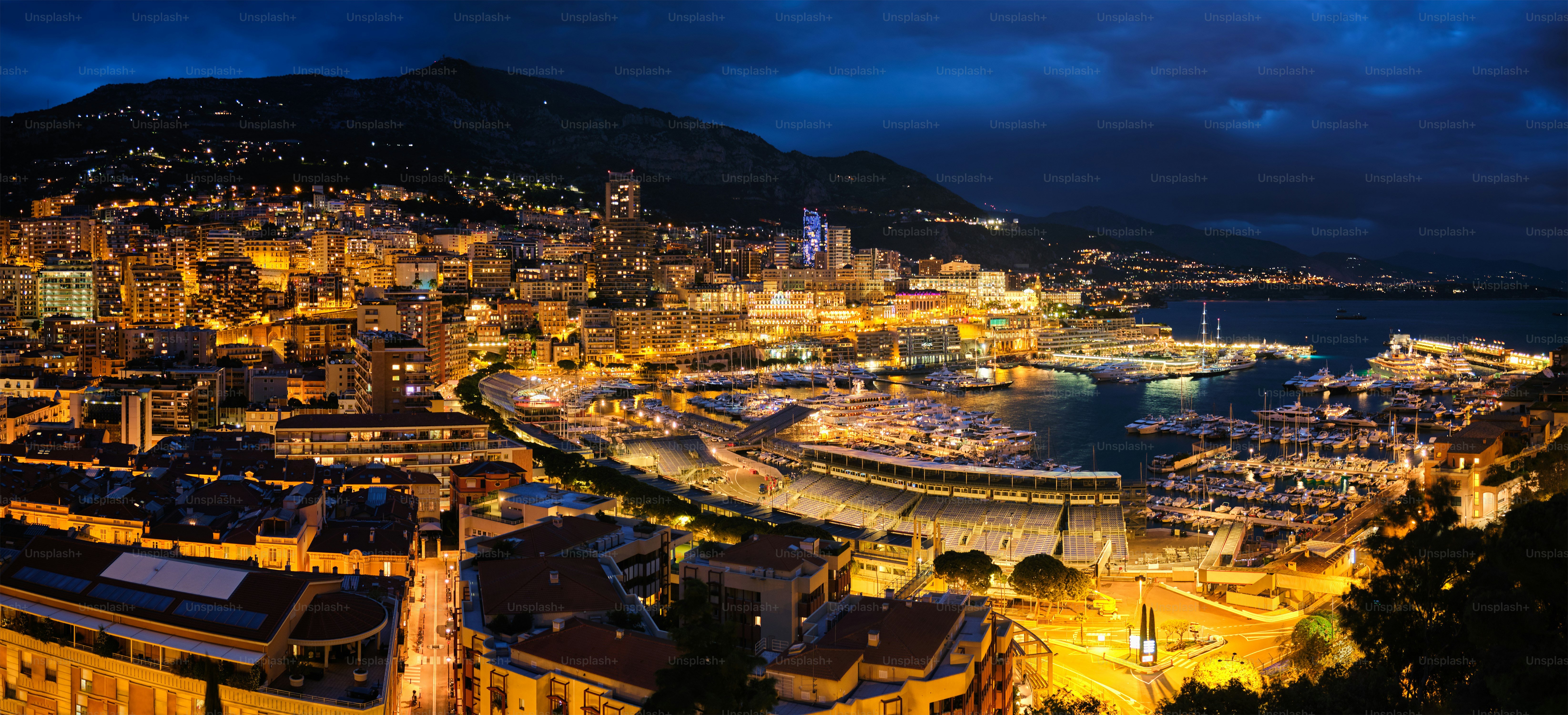 Aerial panorama of Monaco Monte Carlo harbour and illuminated city skyline in the evening blue hour twilight. Monaco Port night view with luxurious yachts